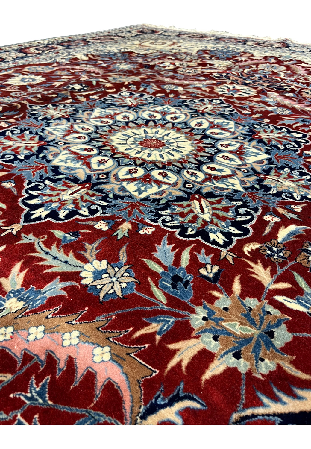 Close up of Persian Isfahan rug medallion showing fine wool knotting, layered floral symmetry, and rich red and ivory contrast