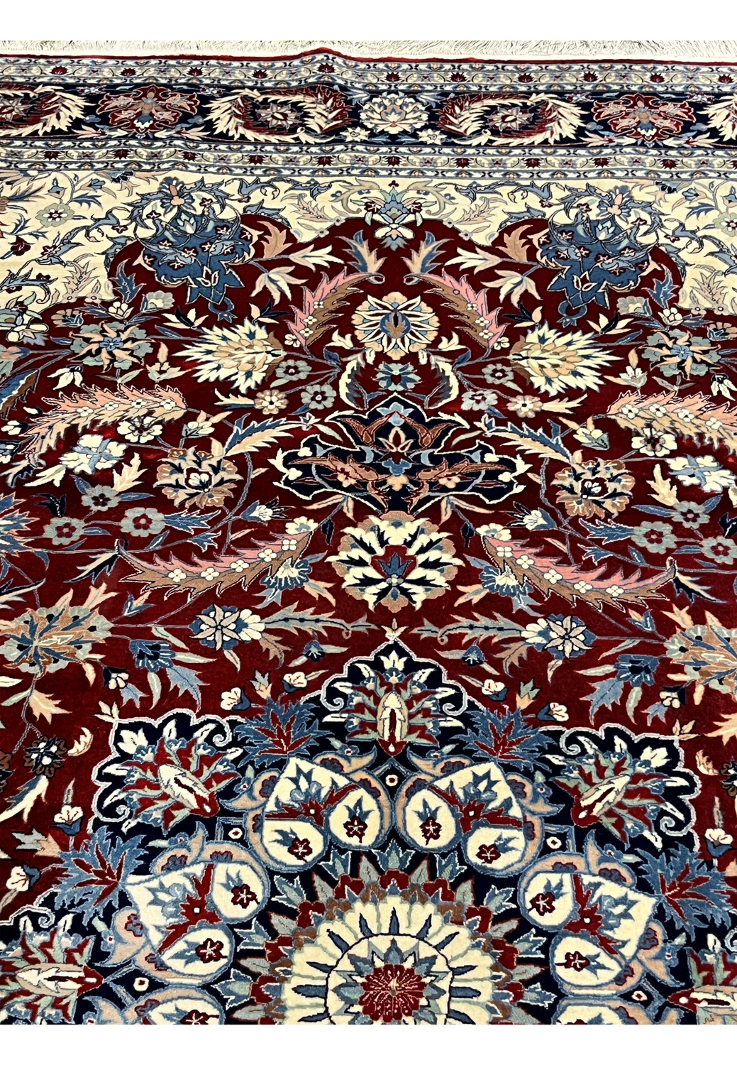 Upper section of floral Persian Isfahan rug featuring scrolling vines, palmettes, and refined color transitions on an ivory field