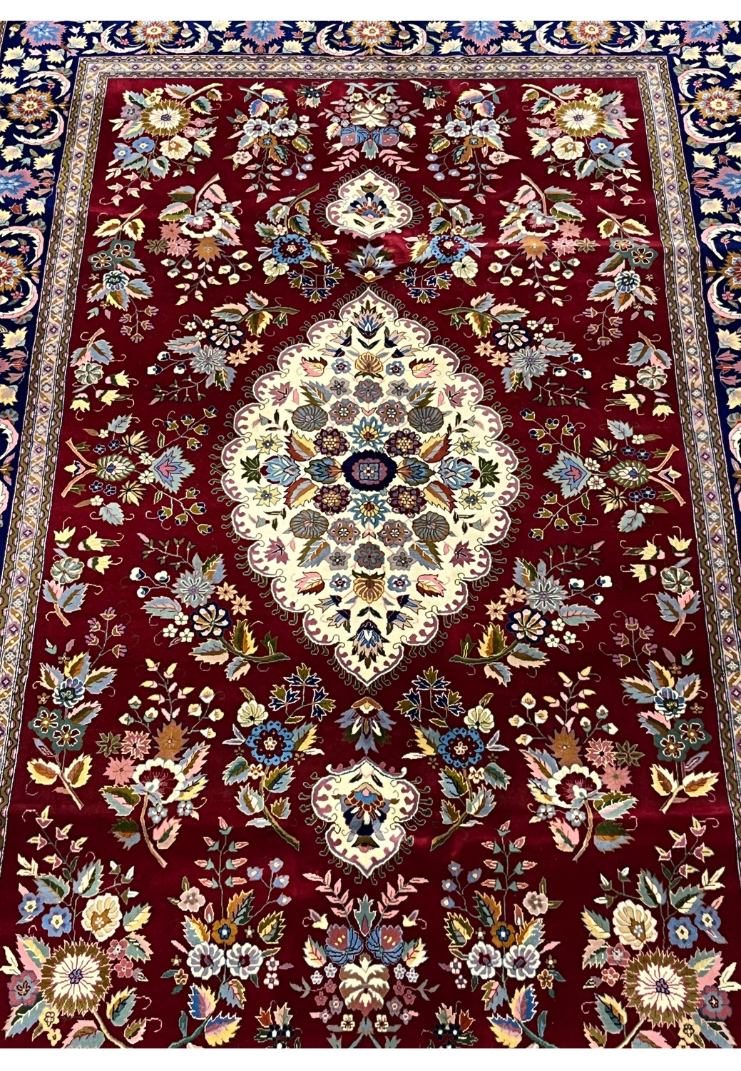 Midfield detail of Persian Isfahan rug highlighting ivory medallion and silk floral accents