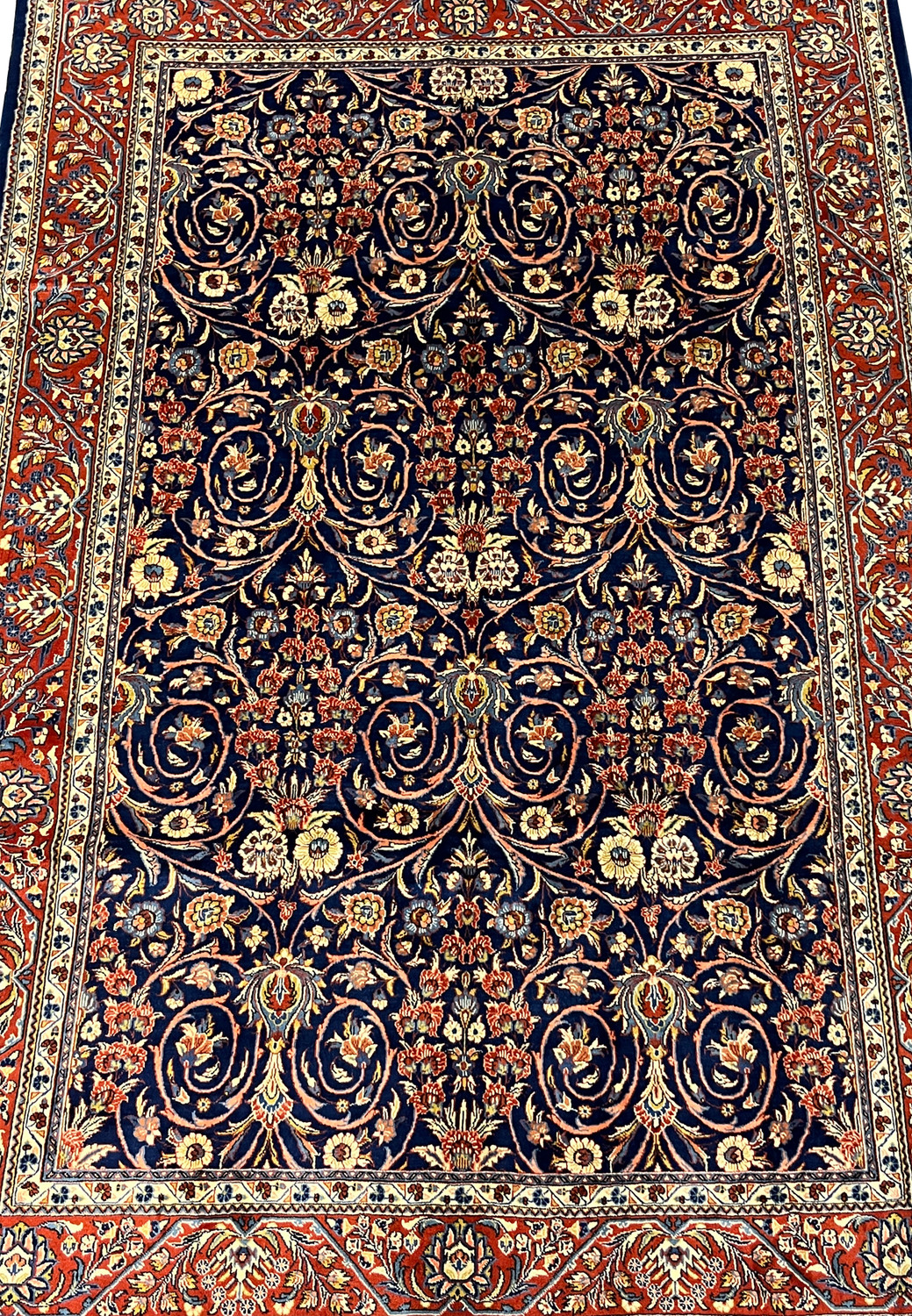 Close view of navy field with intricate floral vines on a Persian Sarough rug