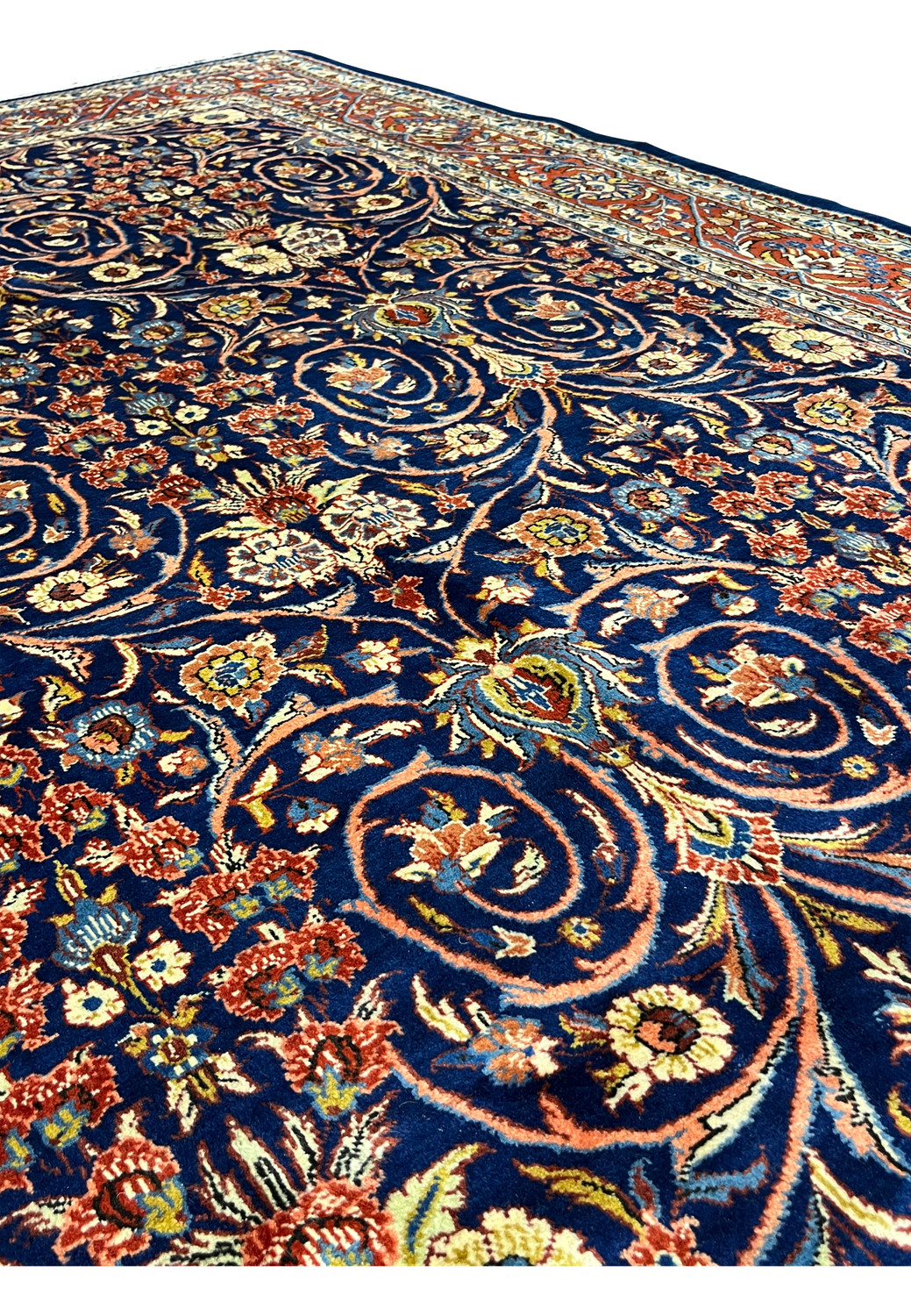 Close-up of navy blue field on Persian Sarough rug with dense floral vines and hand-knotted wool texture