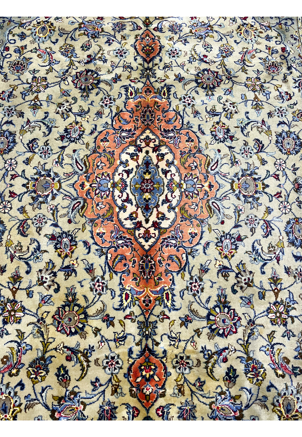 Close-up of central medallion on green Persian Kashan rug with fine floral detailing