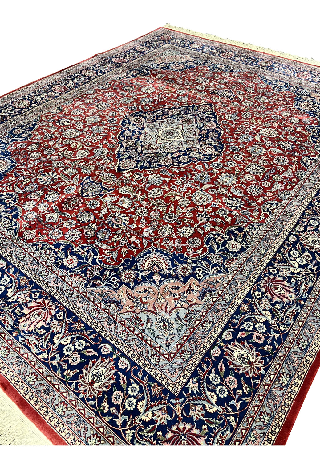 Angled overview of Persian Kashan rug emphasizing medallion layout