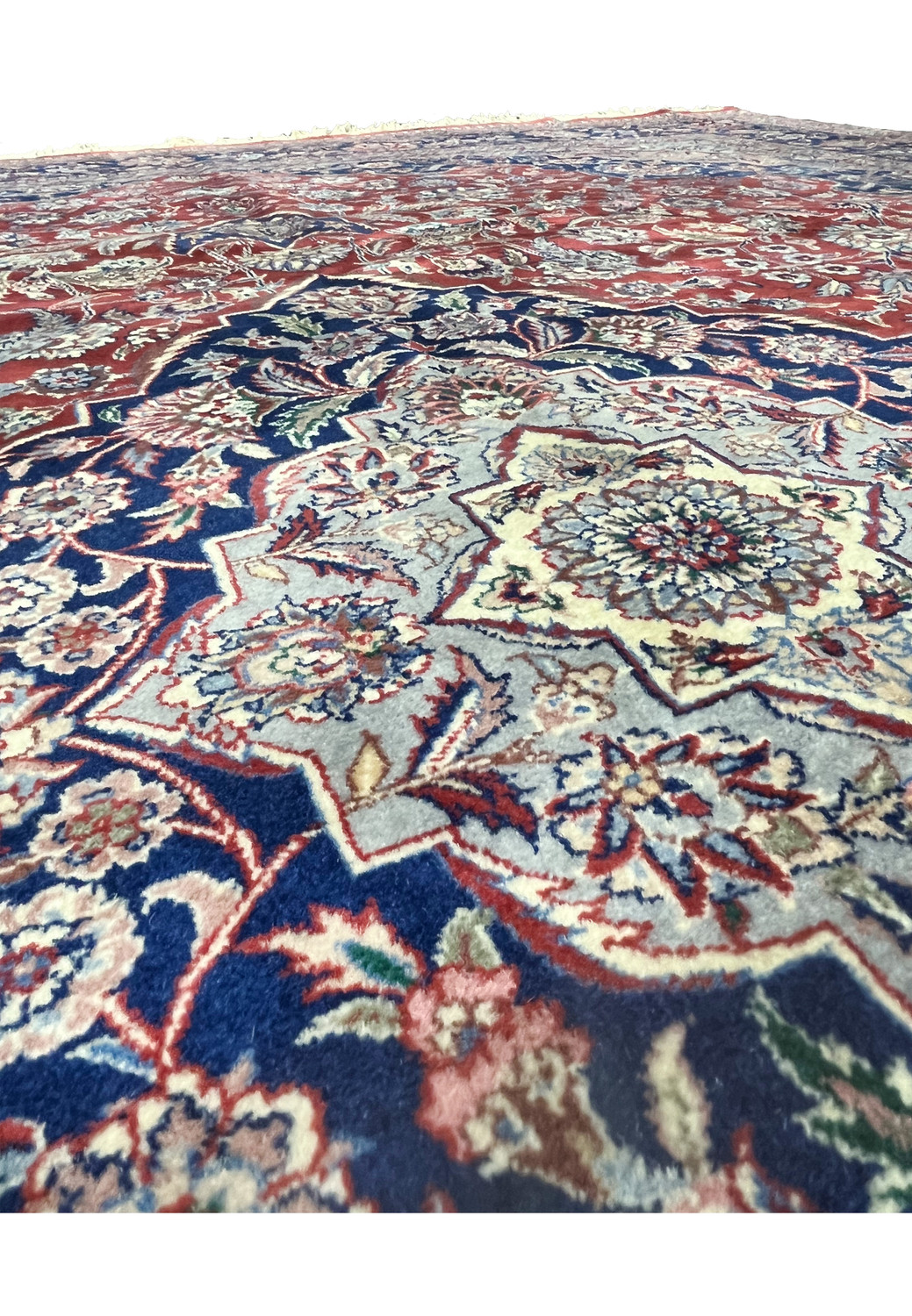 Detailed view of central medallion on antique Persian Kashan rug highlighting navy outlines and ivory floral symmetry