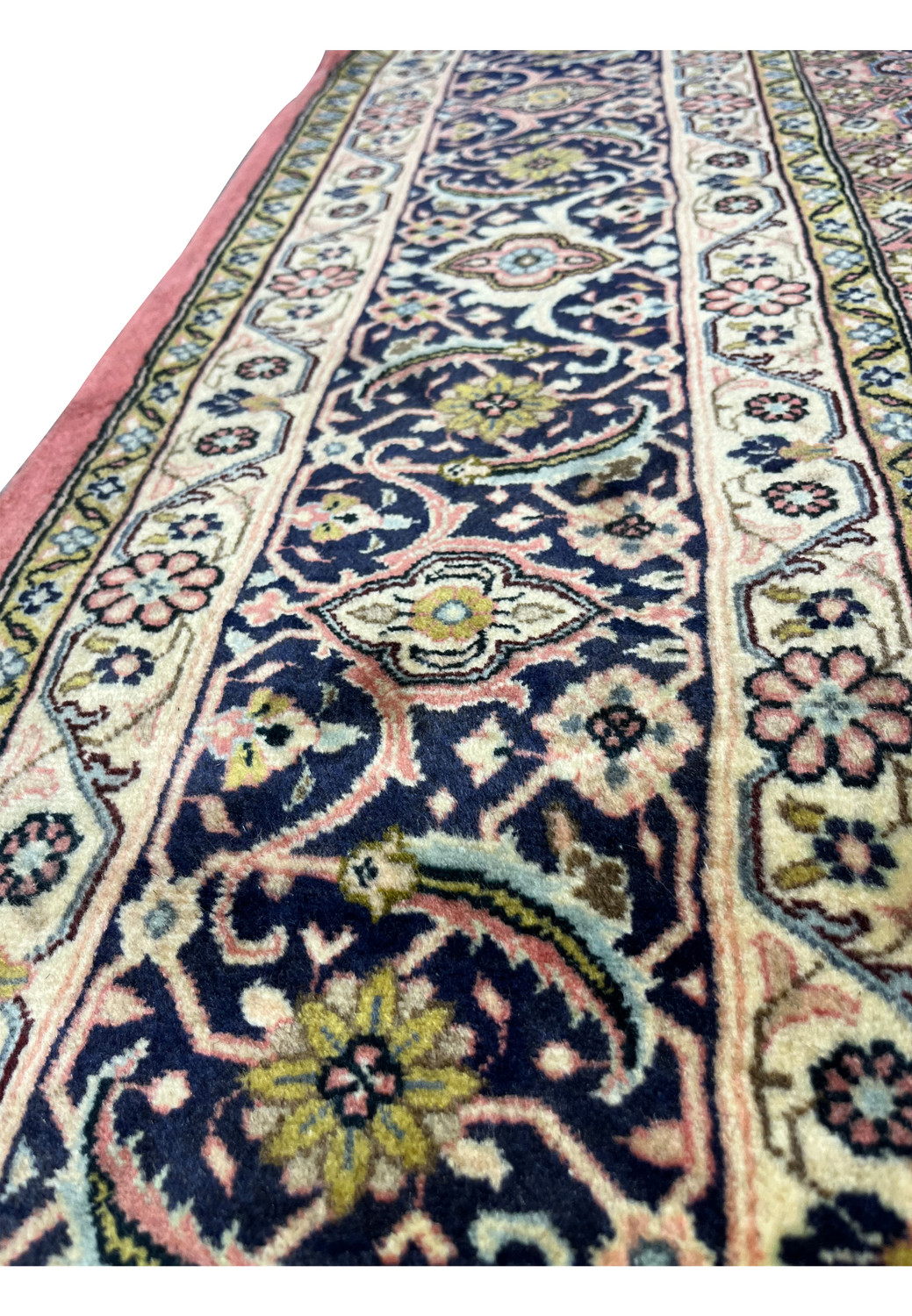 Side border view of Persian Bijar iron rug with scrolling vines, floral rosettes, and crisp color contrast