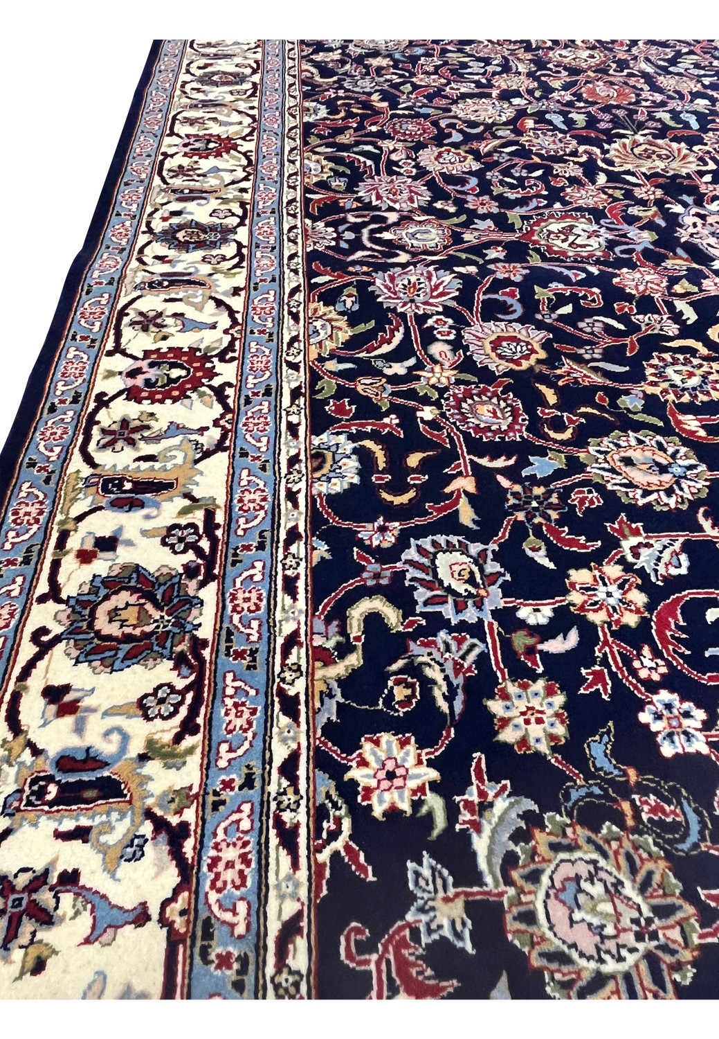 Close up of Persian Sarough rug showing transition between ivory border and navy floral field