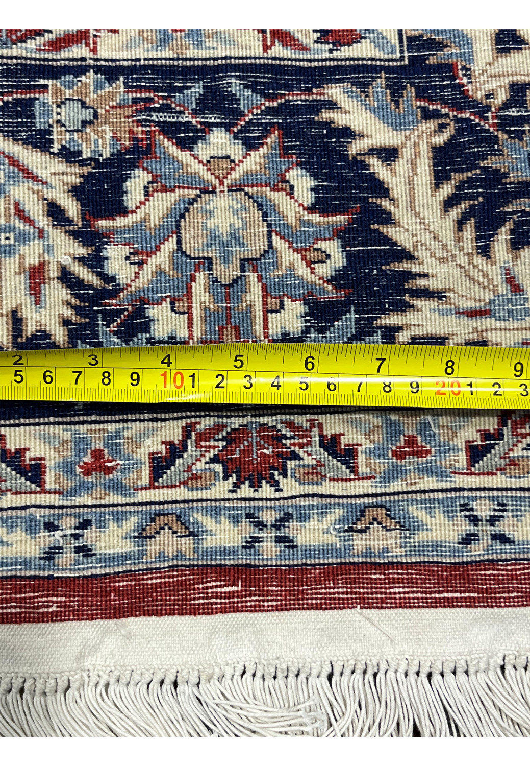 Backside of 5'6 x 8 Persian Tabriz rug with ruler showing tight knot density, straight weave, and precise width measurement
