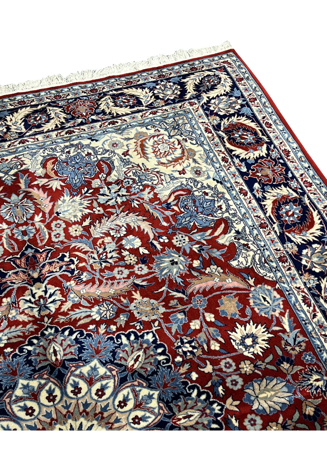 Upper edge of 5'6 x 8 Persian Tabriz rug with burgundy field, navy blue border, ivory floral guard bands, and white hand-knotted fringe