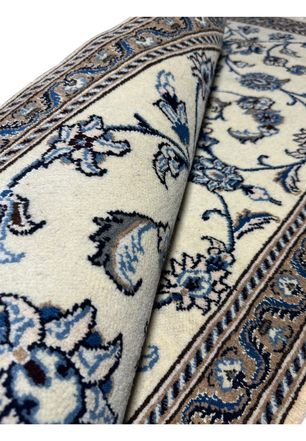 Rolled Persian Nain rug revealing thickness, flexibility, and fine wool construction