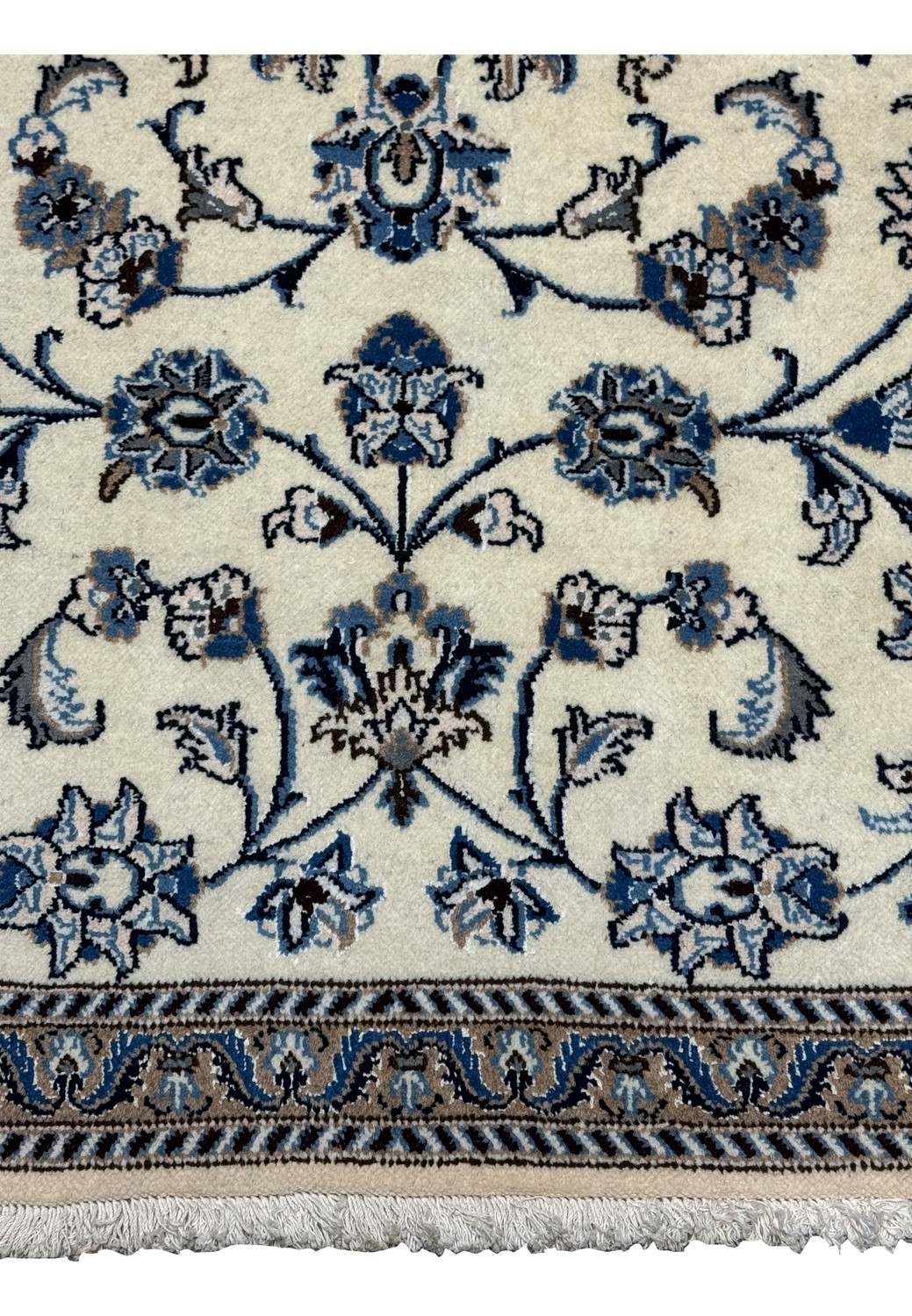 Lower border detail of Persian Nain rug with layered blue floral motifs and fine outlines