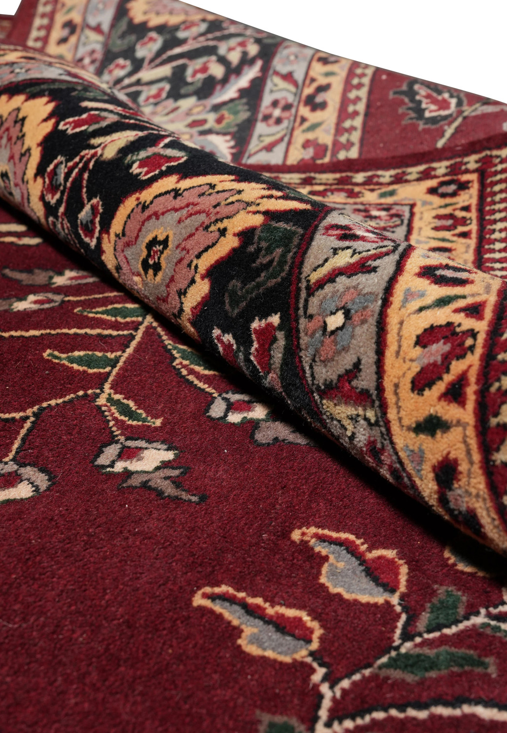 Rolled view highlighting density and construction of oversized Sarough rug