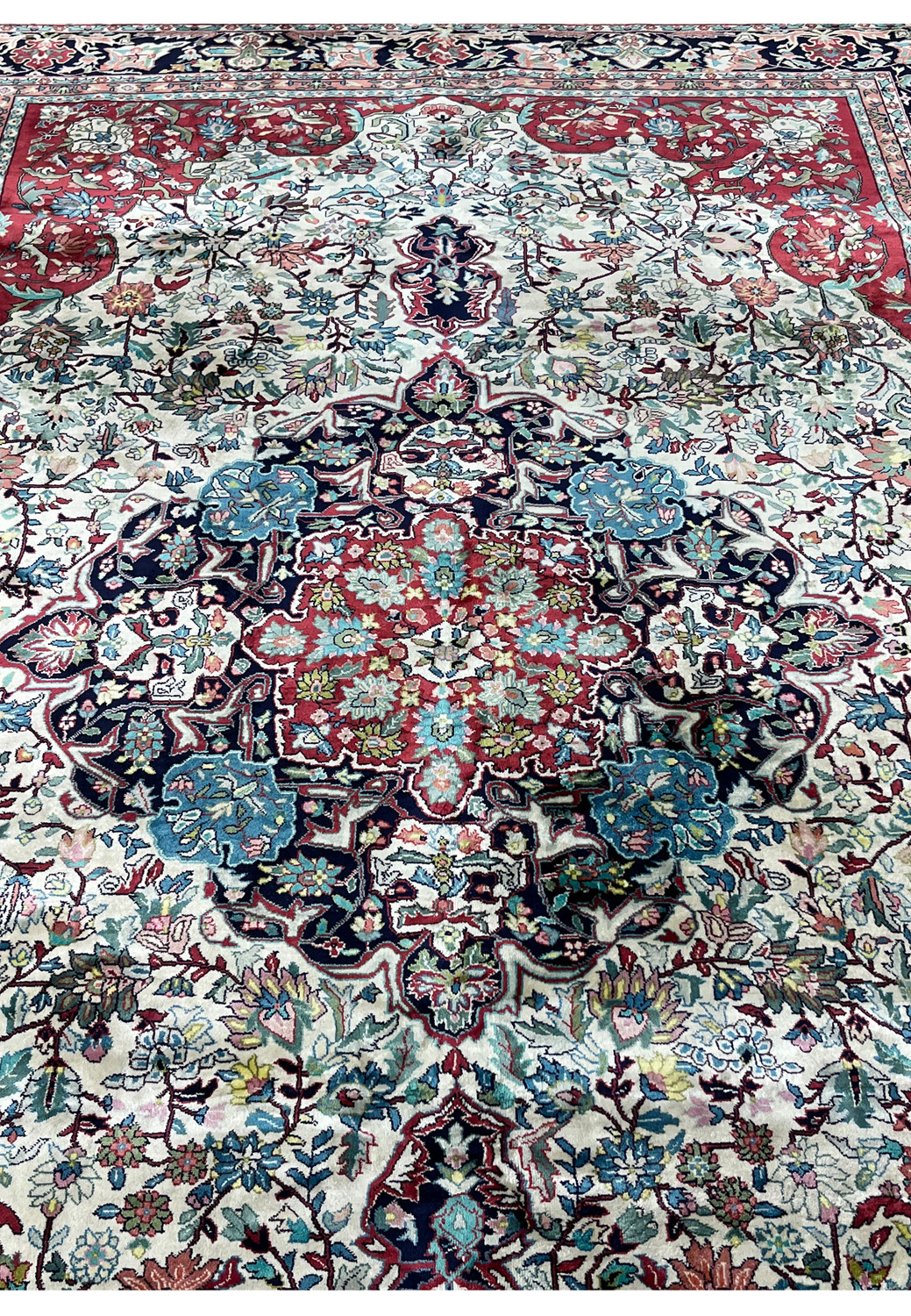 Midfield floral detailing on finely woven silk oriental rug
