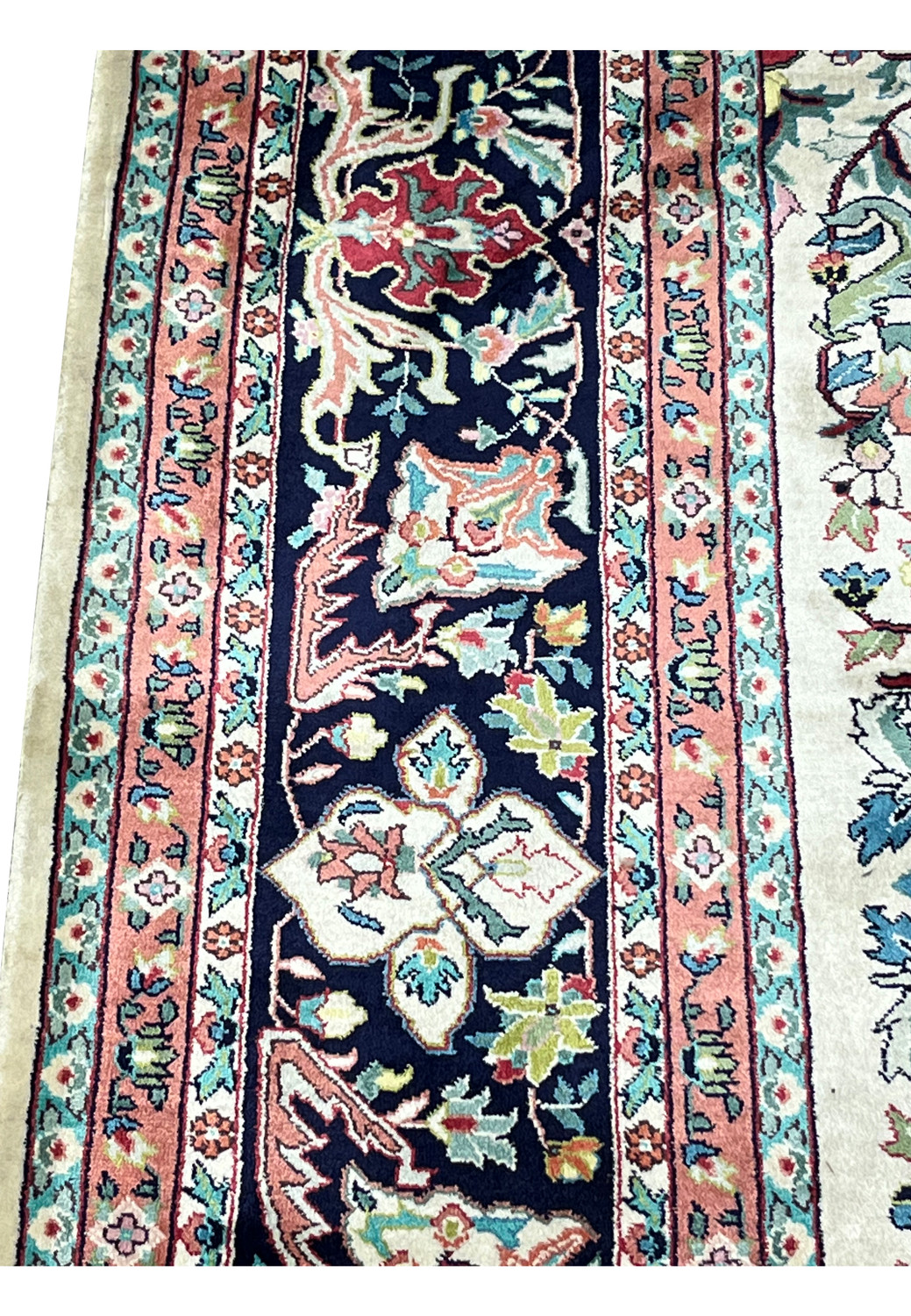 Close-up of 6x9 oriental silk rug border showing navy blue ground with floral vines in blush pink, ivory, teal, and soft green
