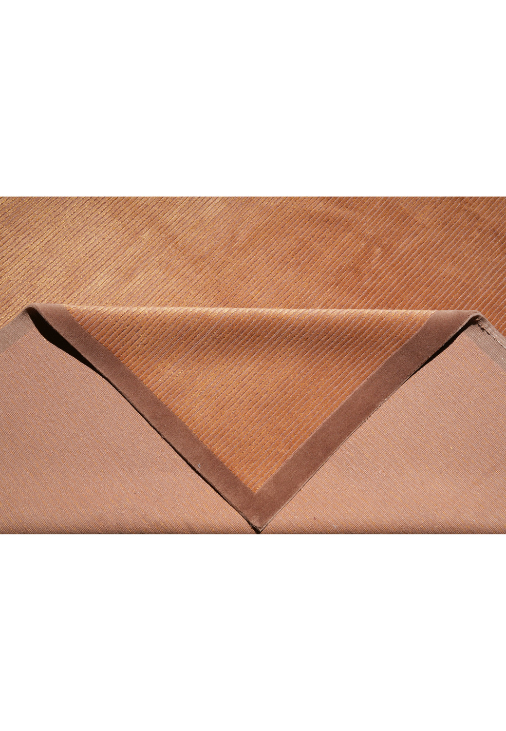 Folded edge detail highlighting the flexible wool foundation and silk accents that create a soft, smooth, and refined rug surface