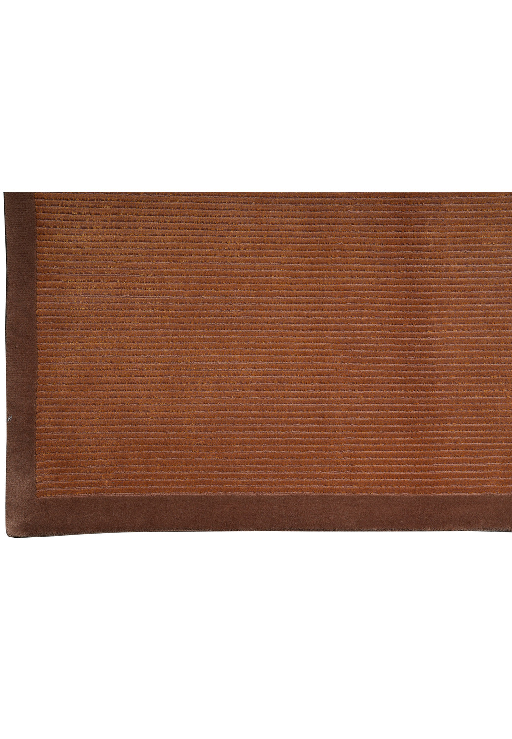 Close-up of the refined border framing this handmade Tibetan rug, showing deeper brown tones that subtly contrast the textured field