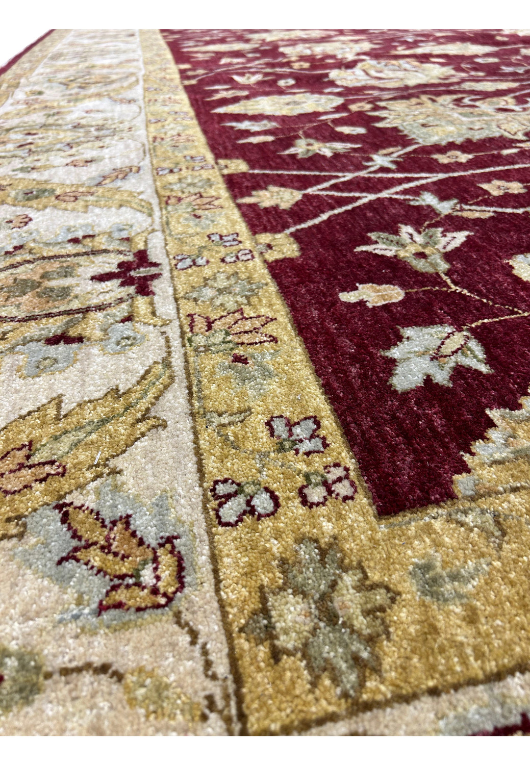 Close-up of the wide gold border with floral motifs on an Oriental Zigler Chobi rug