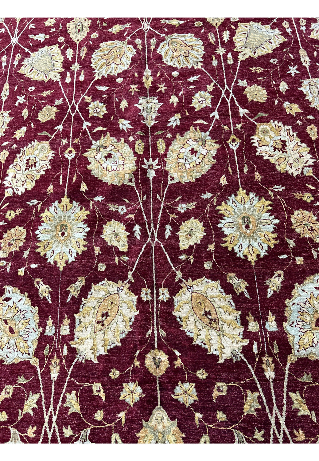Midfield detail with floral palmettes and vine motifs on a burgundy Chobi Peshawar rug.