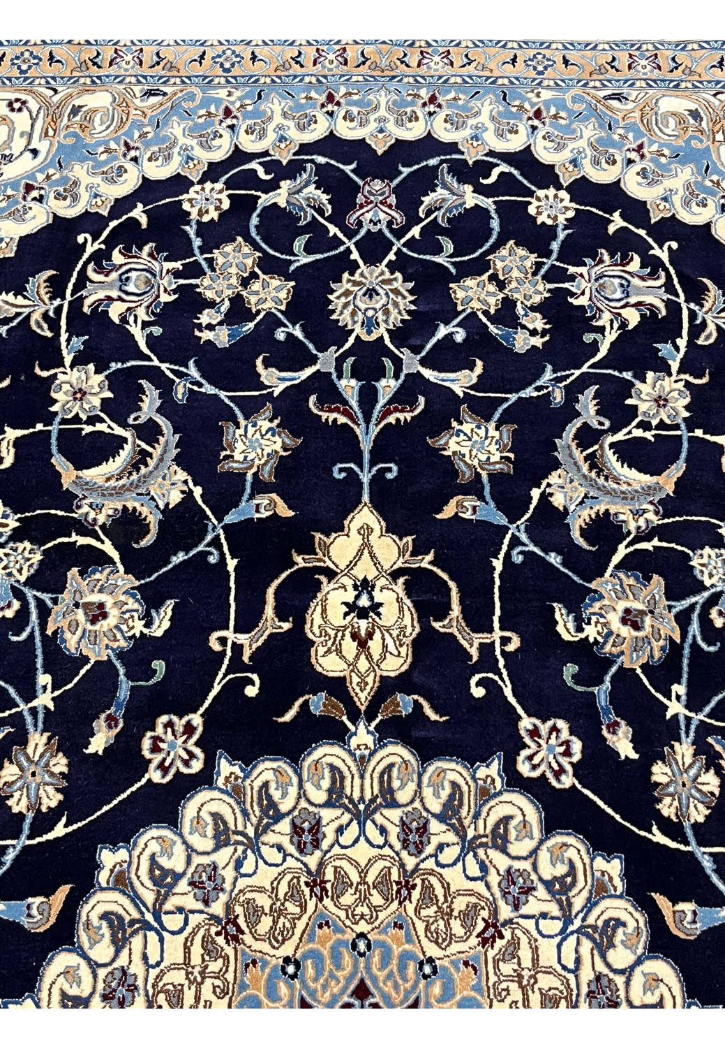 Upper section of a 6'5 x 10 Persian Nain 6 LA rug showing midnight navy field with ivory floral vines, silk highlights, and finely detailed curvilinear motifs