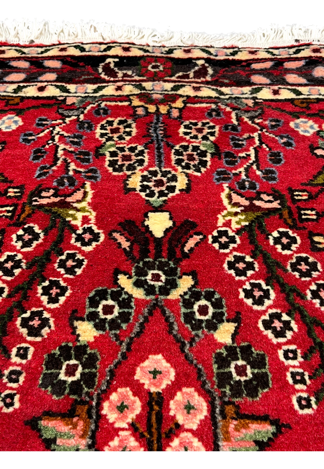 Upper section view of a Persian Darjazin rug showing floral vines, balanced medallion extensions, tight knot density, and harmonious tribal composition