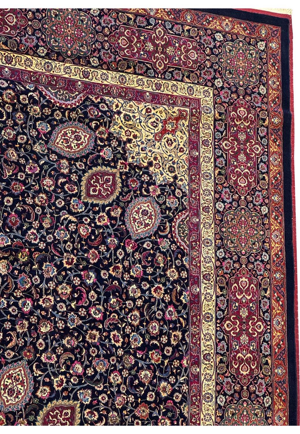 Upper border detail of a signed Persian Mashad rug featuring intricate floral vines, rich red tones, navy outlines, and subtle silk highlights.