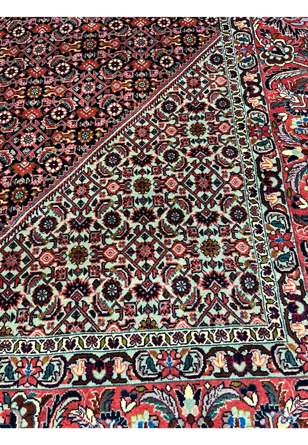 Close view of inner border on a 9'8 x 13'7 Persian Bijar iron rug showing dense geometric motifs, red field tones, ivory outlines, and tight wool knotting