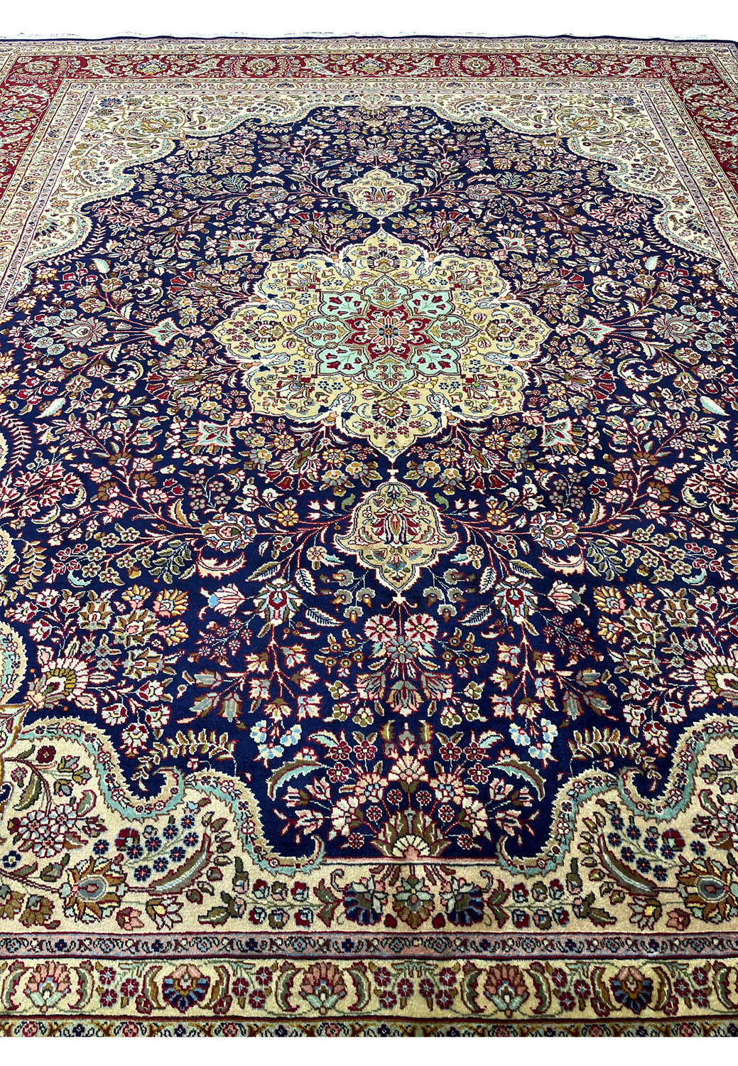 Persian Tabriz rug field showing deep navy base with continuous floral vines, burgundy accents, and refined traditional Persian layout