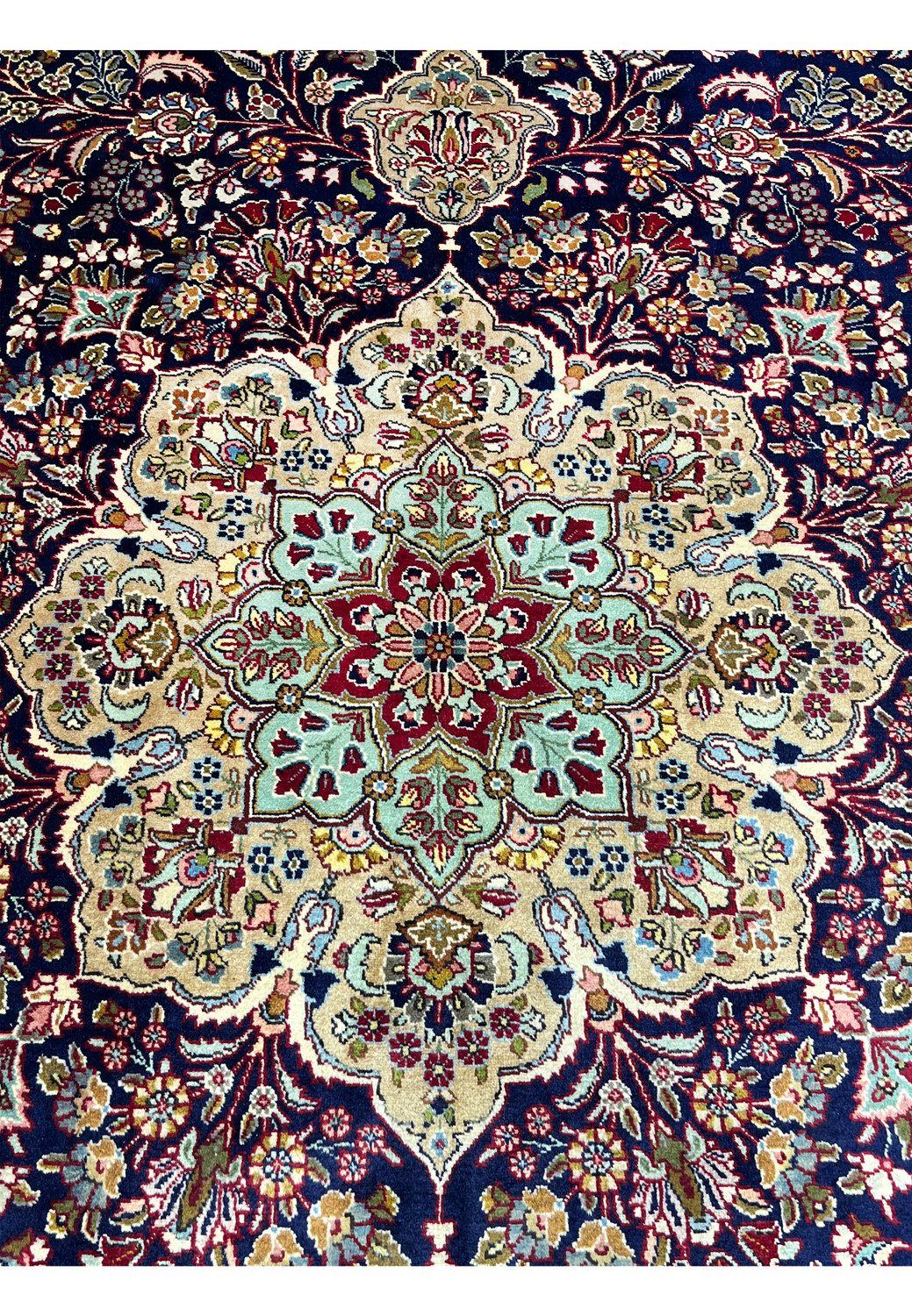 Zoomed detail of Persian Tabriz rug medallion highlighting intricate floral motifs, tight knotting, and refined color transitions