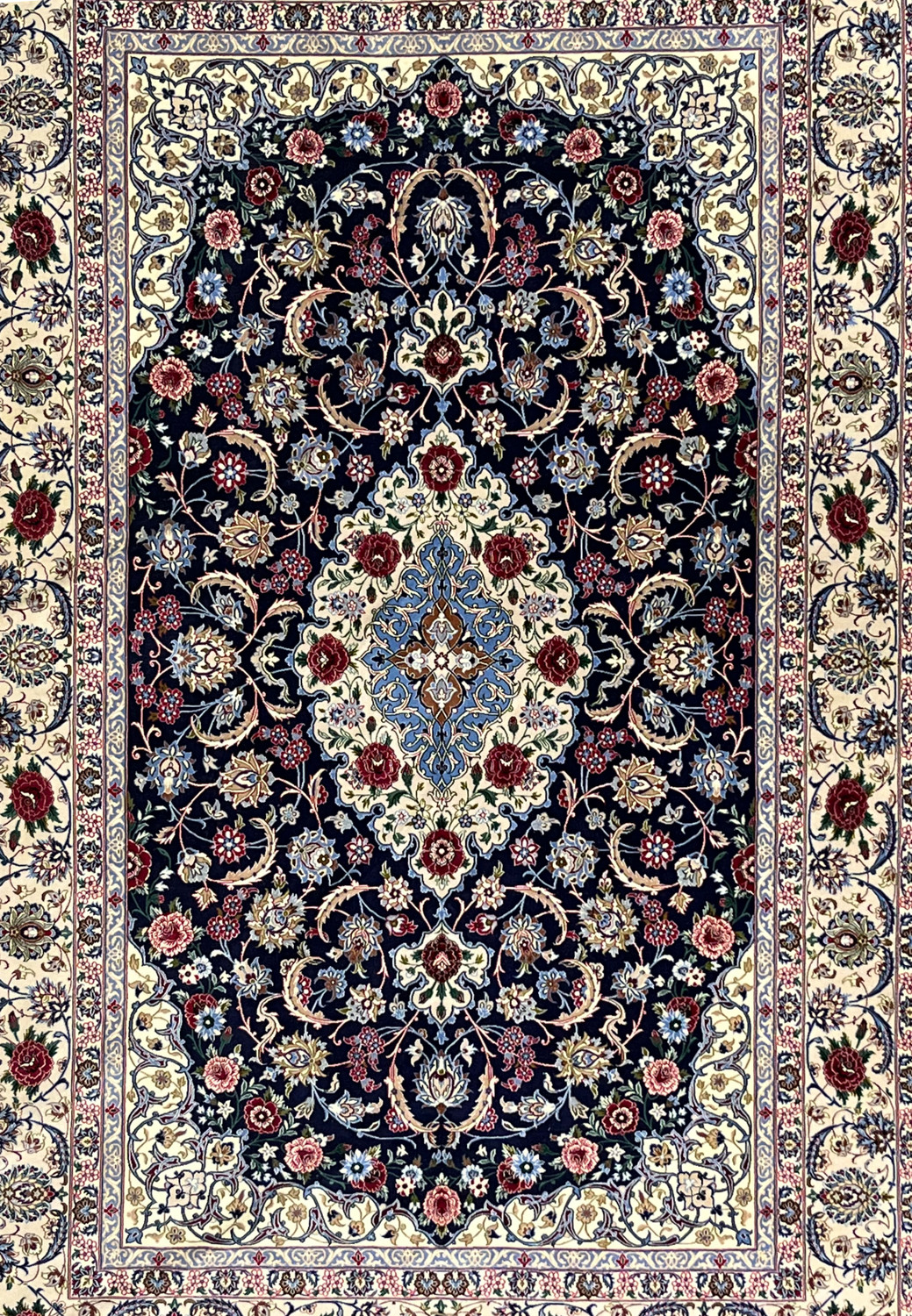 Midfield detail of super fine Persian Isfahan rug highlighting navy ground, scrolling floral vines, silk highlights, and precise hand knotted detailing