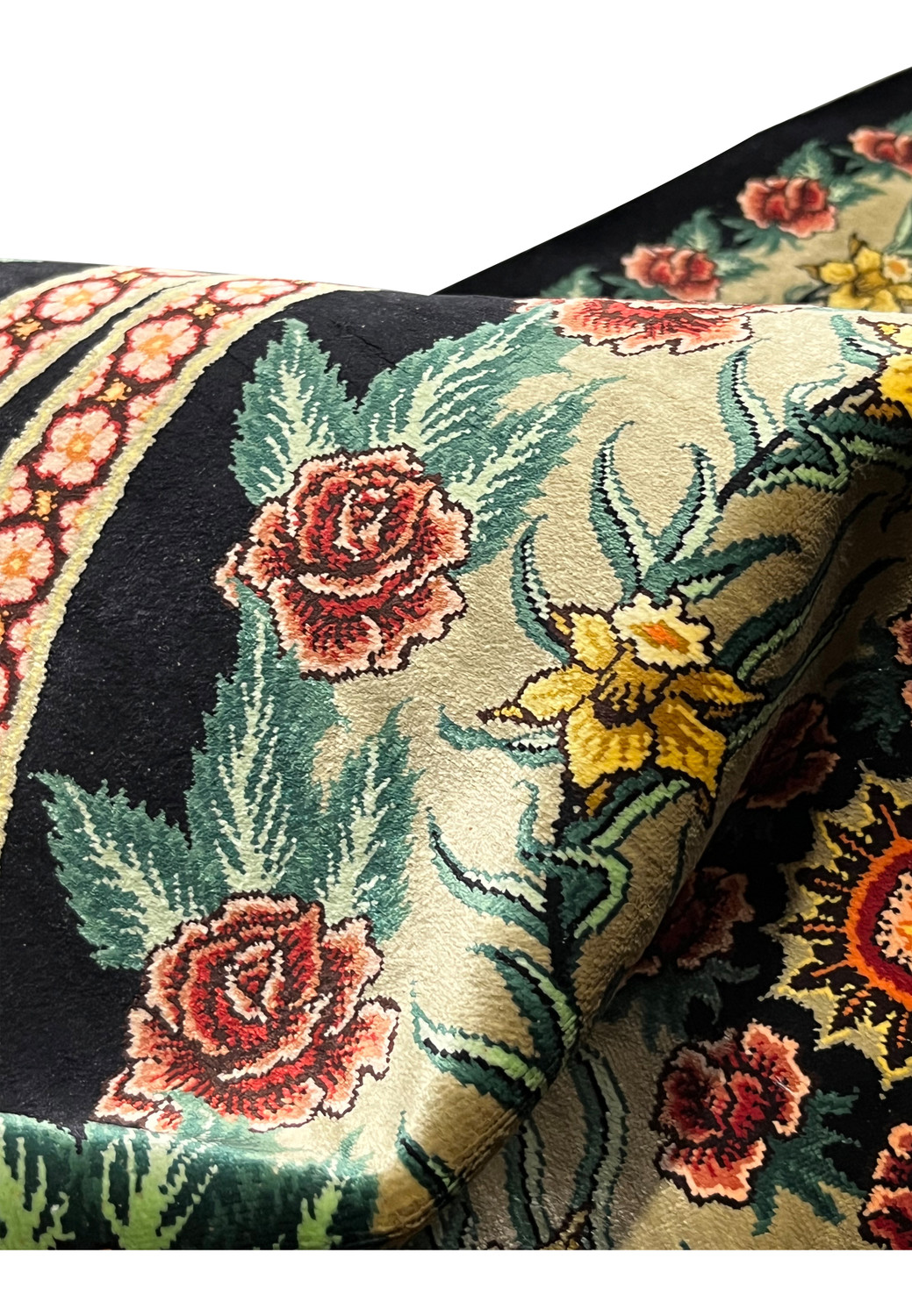 Silk pile close-up of a signed Persian Qum rug revealing high knot density, smooth texture, and sharp definition in floral outlines and borders