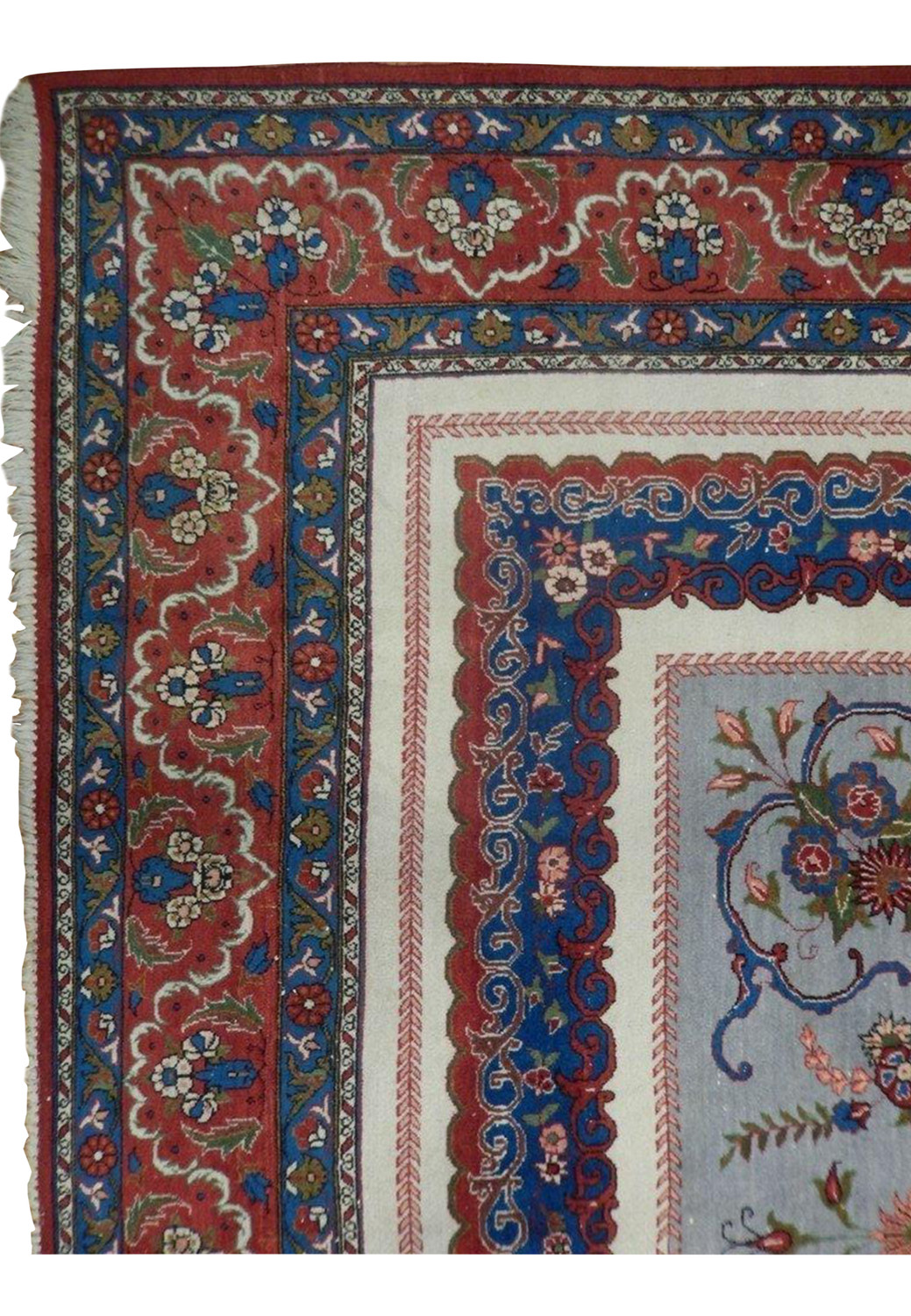 Detailed border corner of a Persian Isfahan rug featuring rich red borders, blue guard bands, floral motifs, and precise hand-knotted detail