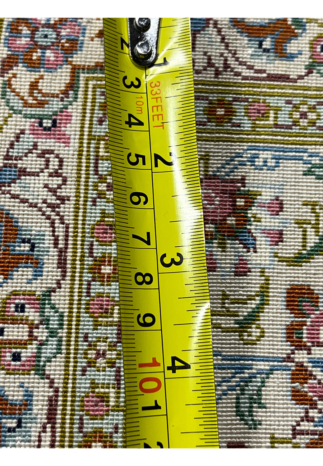 Back of a Persian Qum pure silk rug with measuring ruler visible, highlighting tight knot count, precise weaving, and high-quality silk construction.