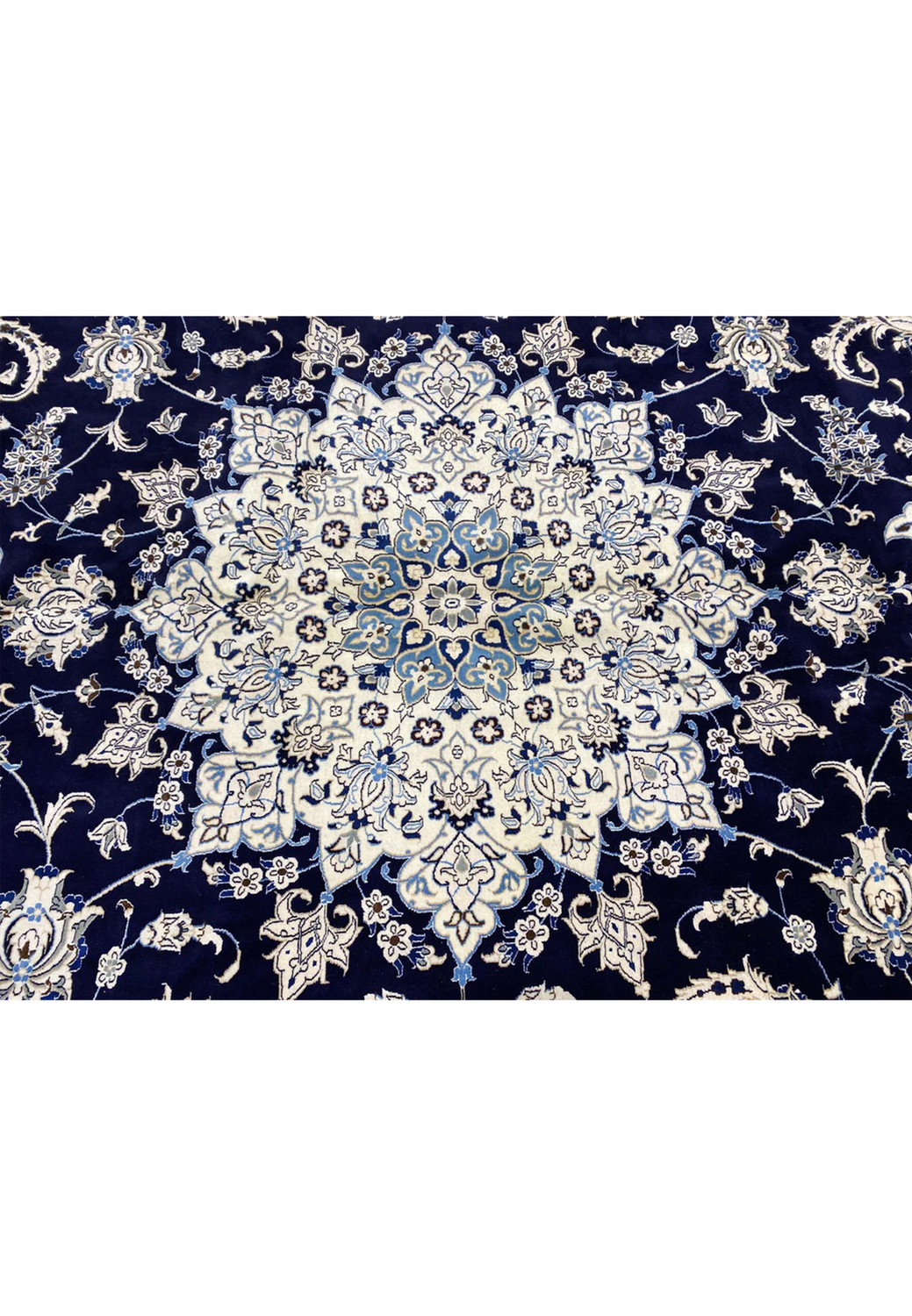 Central medallion of a rare 10x19 Persian Nain 9 La rug with ivory layered floral design set against a deep navy blue field