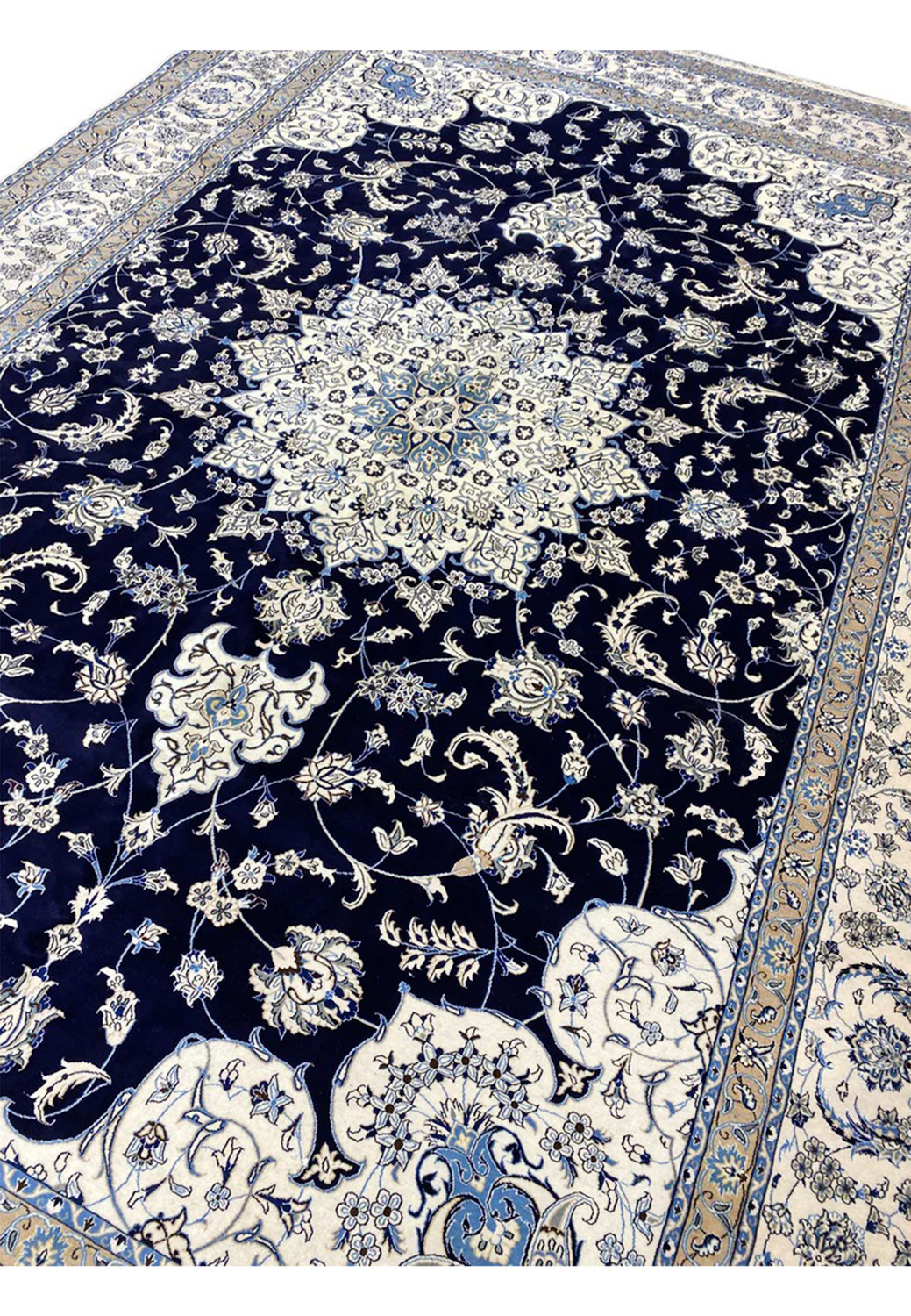 Angled view of a 10x19 navy blue Persian Nain 9 La rug showing the elongated format, luminous medallion, and elegant floral field