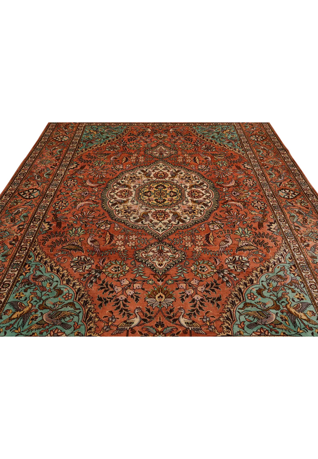 Midfield detail of a signed Paradies Persian Tabriz rug featuring birds among flowering branches on a warm terracotta background