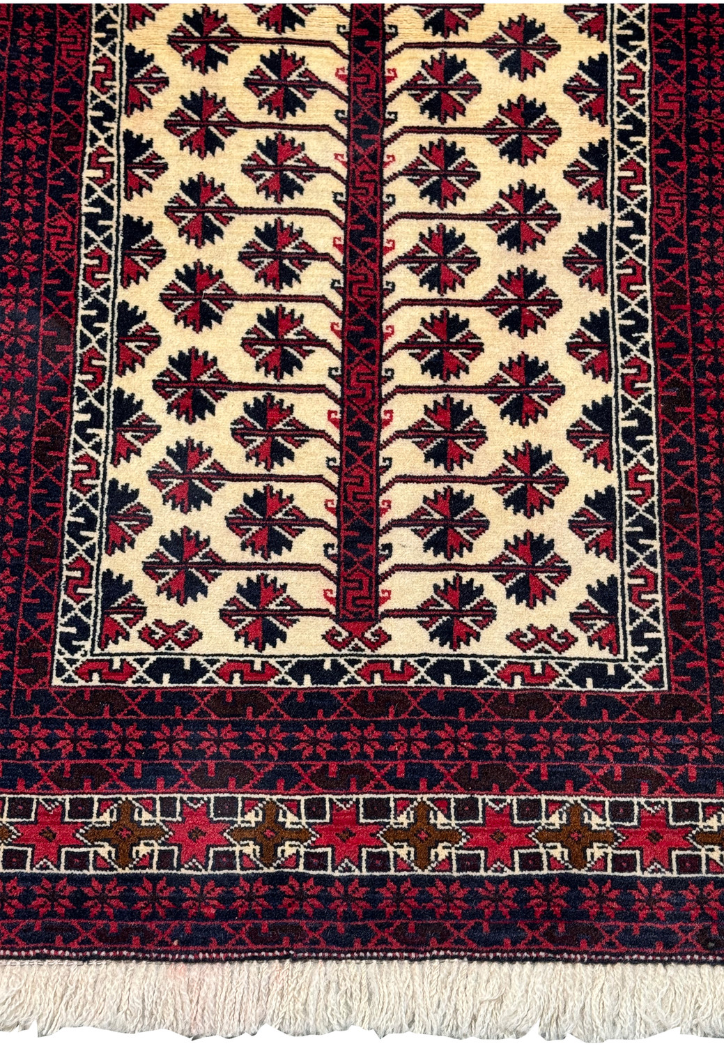 Lower section of a Persian Baluch prayer rug showing stepped mihrab base, geometric borders, and dense tribal weaving
