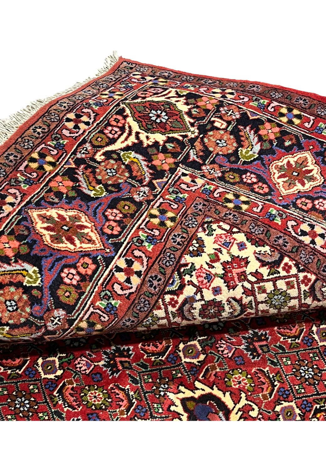 Folded edge view of Persian Bijar rug showing thickness, firm structure, clean borders, and tightly packed hand knotted wool construction