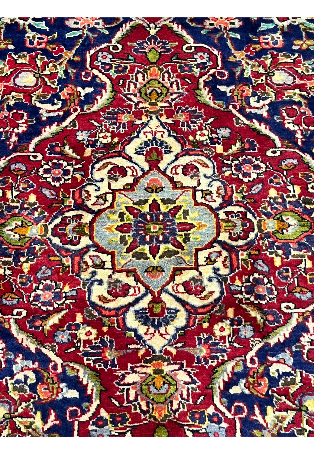 Zoomed medallion detail of Persian Isfahan rug revealing fine knot density, precise floral drawing, and elegant color transitions