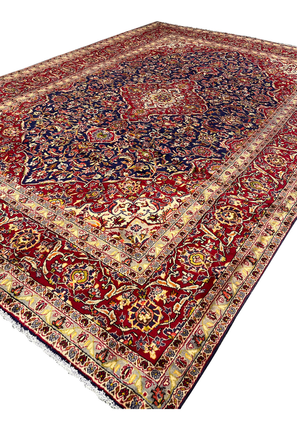 Angled perspective of Persian Isfahan rug displaying overall proportions, navy blue field depth, red medallion, and elegant border framing