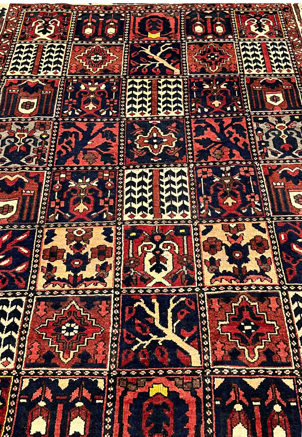 Detailed field view of a Persian Bakhtiar rug displaying garden layout with tribal pictorial squares