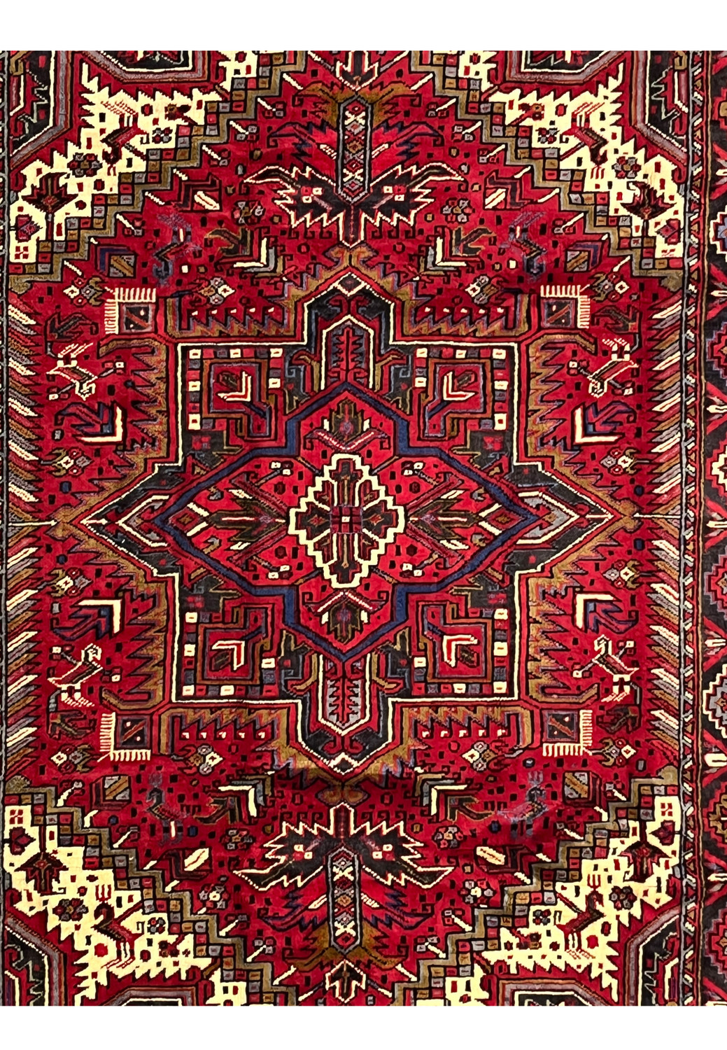 Central medallion detail of Heriz rug featuring stepped star shape layered geometry and strong tribal symmetry in hand knotted wool
