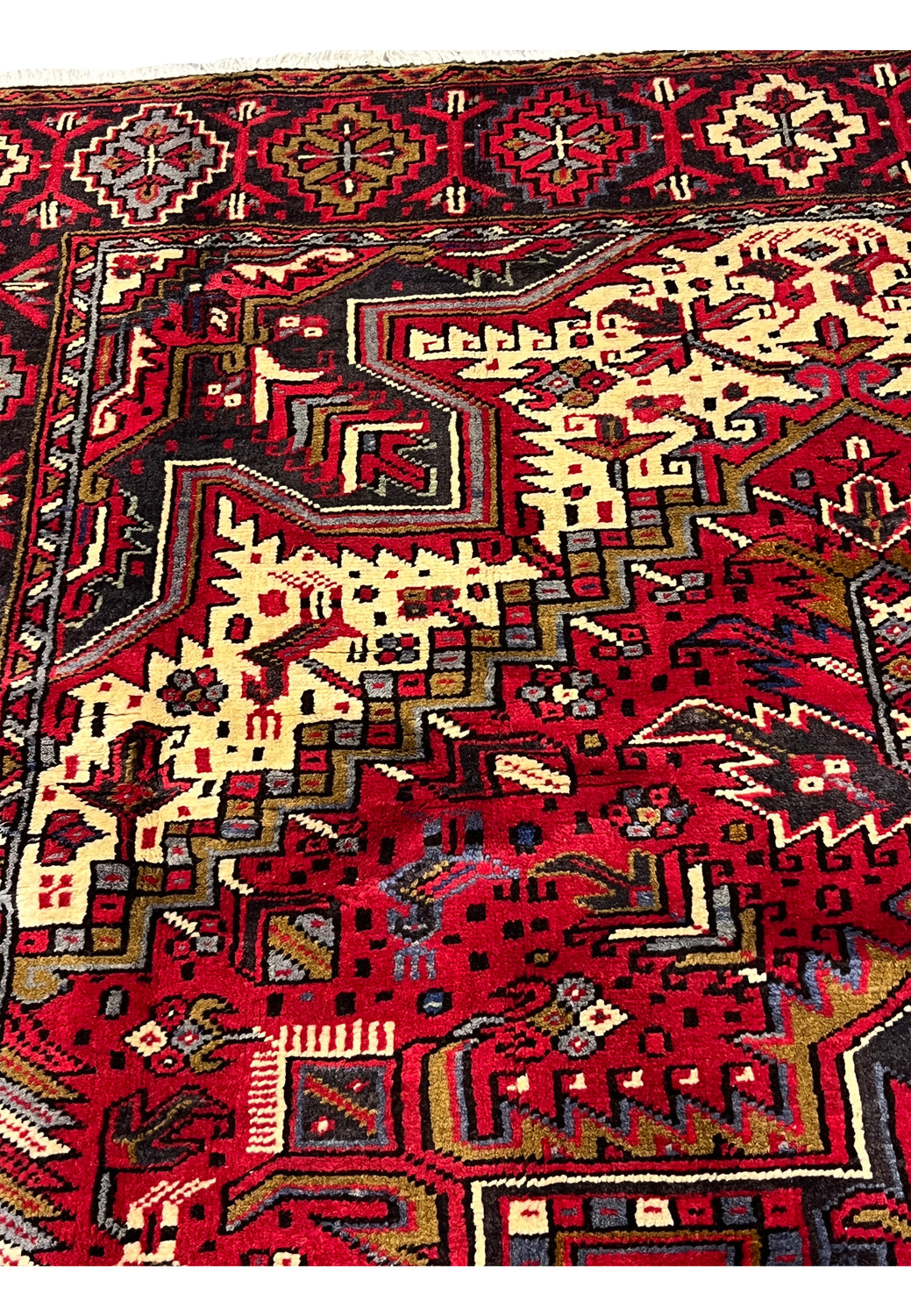 Inner guard border closeup featuring stepped geometric lines, small tribal elements and tight knot structure typical of authentic Persian Heriz rugs