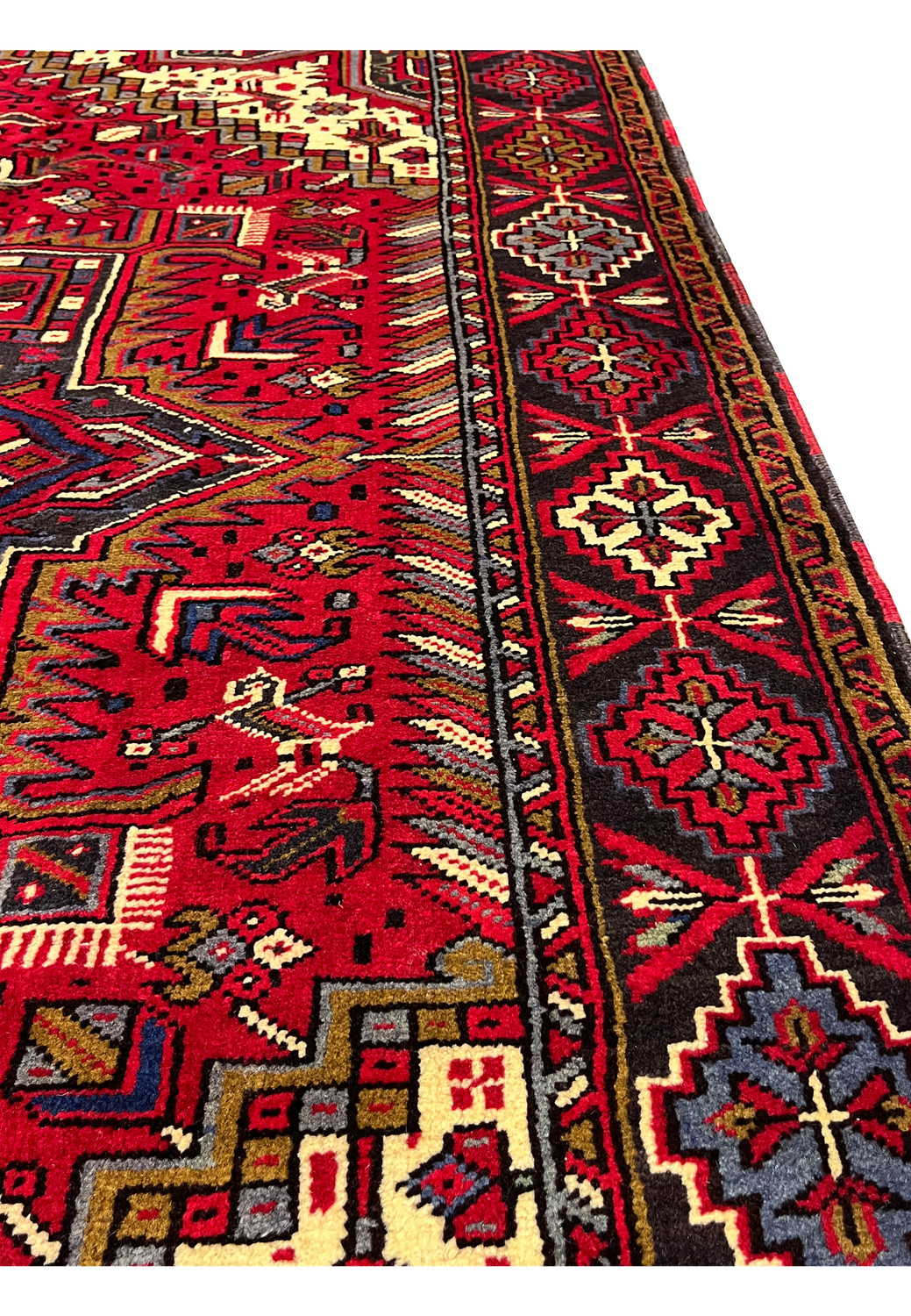 6'4 x 10'1 Persian Heriz rug angled side view showing thick wool pile, bold geometric medallion, red field, tribal border and dense hand knotted texture