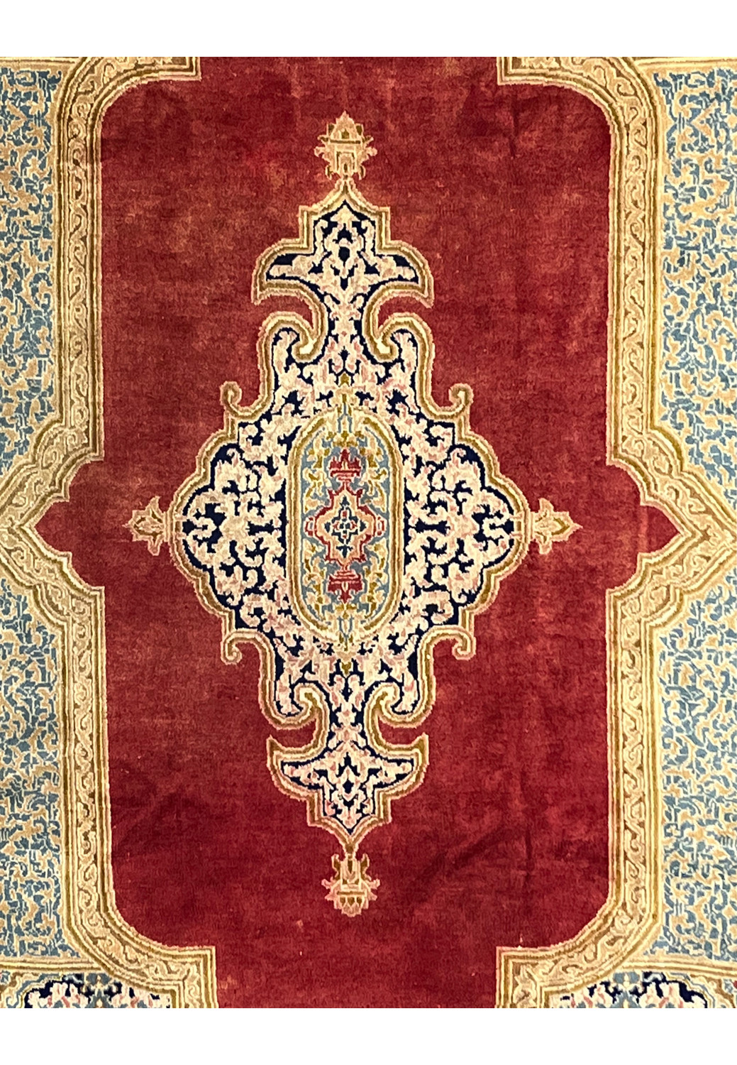 Center medallion detail Persian Kerman rug ivory and navy floral scrollwork on brick red background intricate hand knotted design