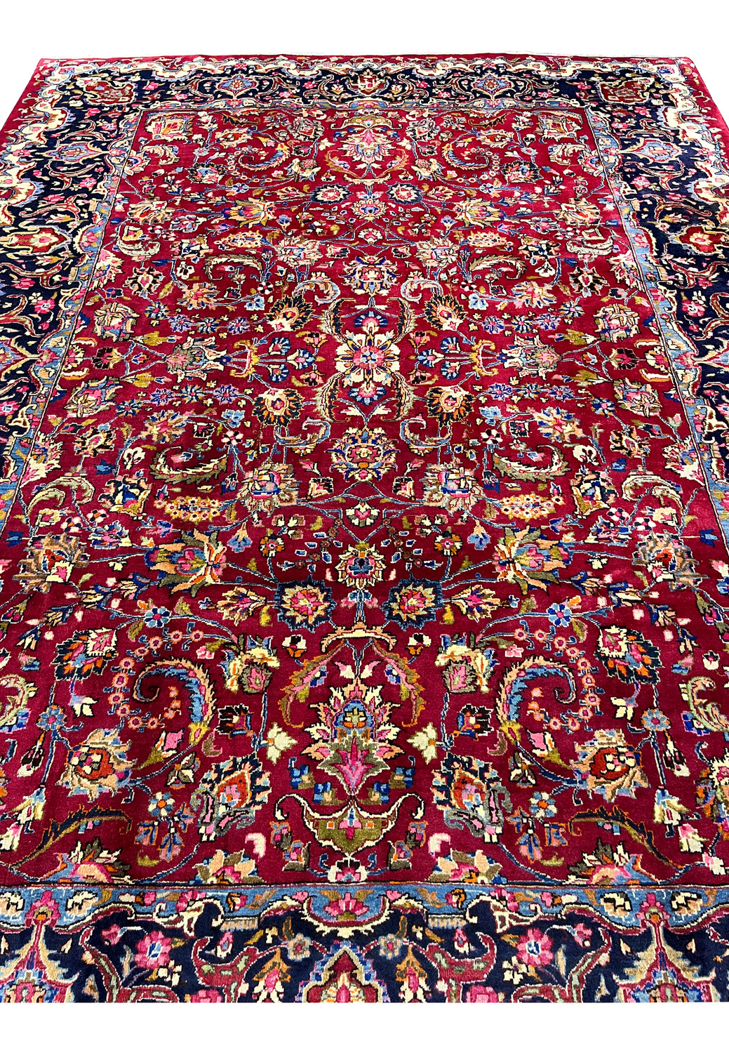 Top down view of signed Mashad rug highlighting symmetrical floral layout, central medallion, and detailed vine motifs