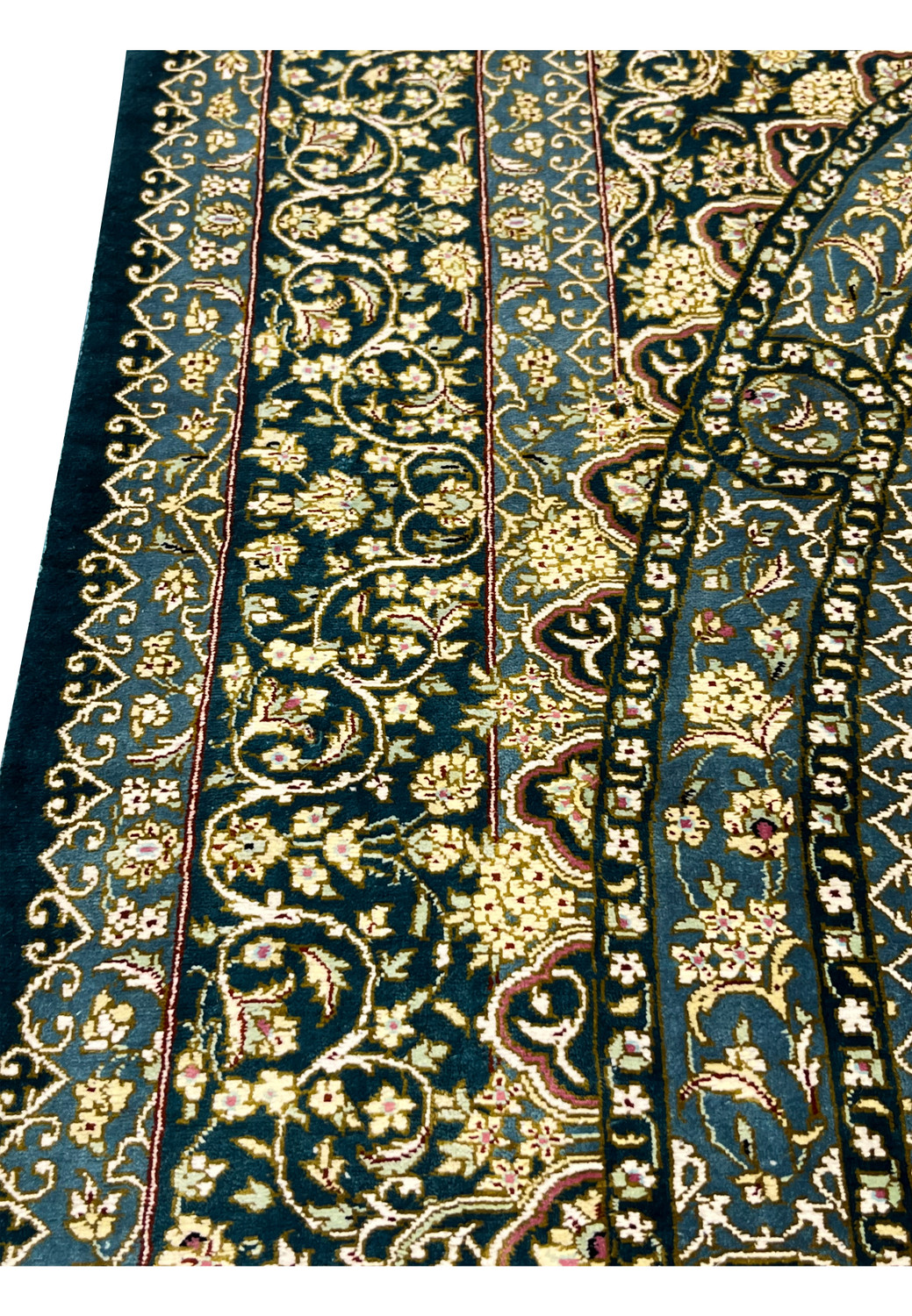 Macro border view showing tight silk knots, scrolling vines and delicate blossoms in ivory gold and navy tones