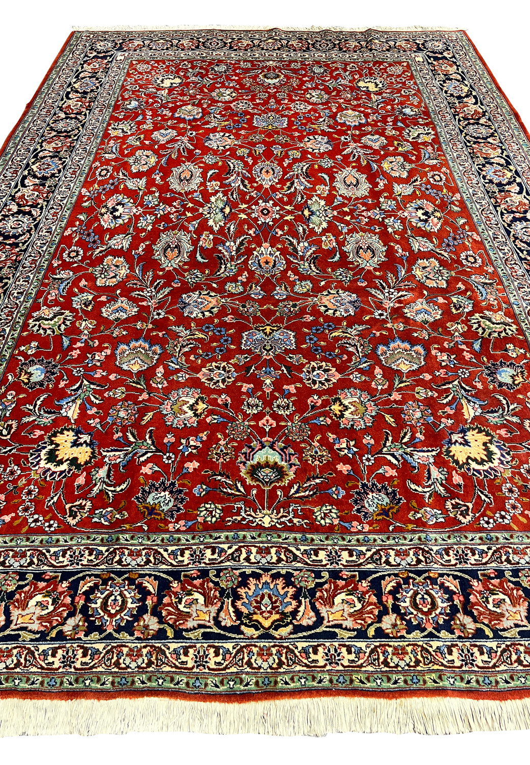 Top down view Tabriz rug red background ivory and blue flowers navy border fine weave botanical layout.
