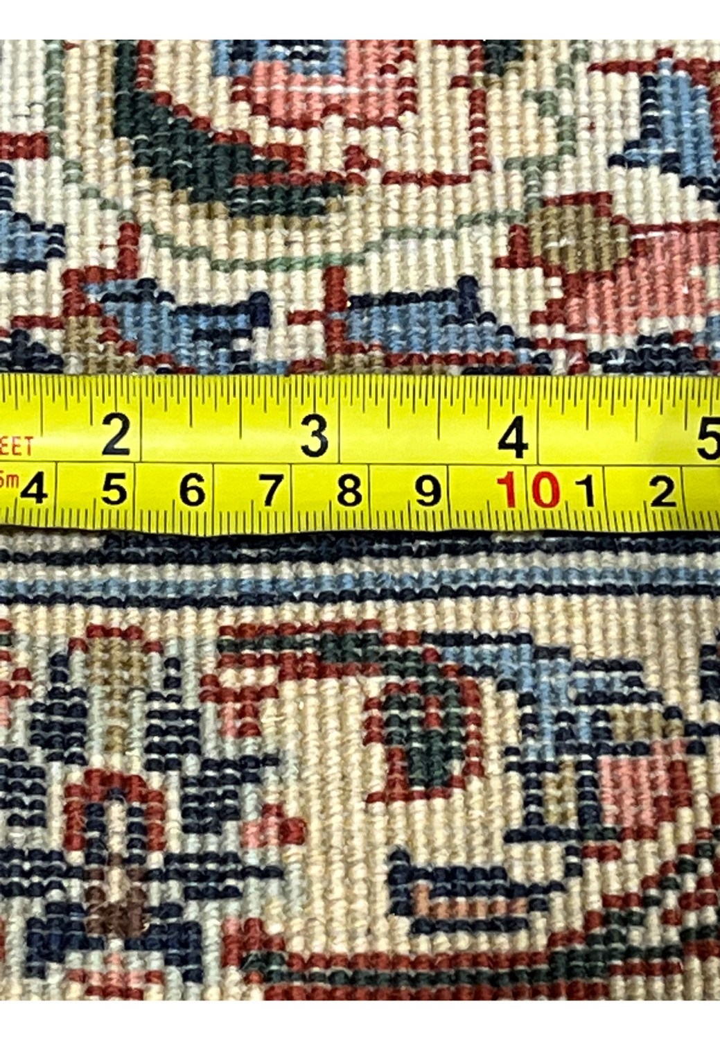Reverse side with measuring tape showing high knot count and compact weave of Persian Tabriz rug, demonstrating detailed hand knotted construction