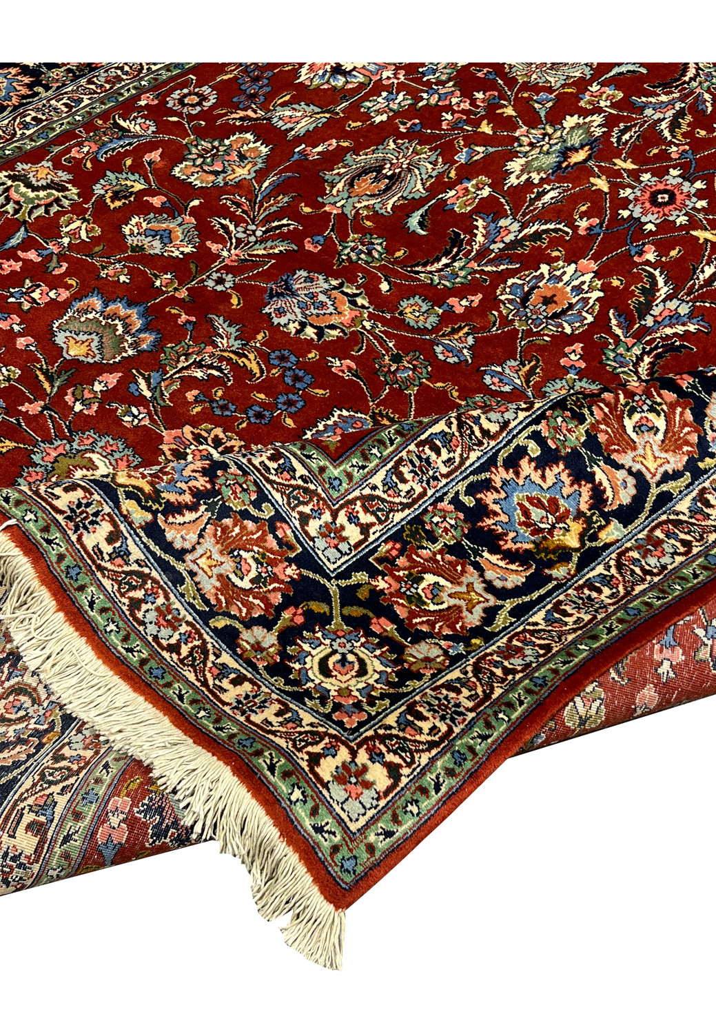 Folded corner of handmade Tabriz rug revealing layered borders, tight weave structure, crisp edge binding and vibrant botanical field pattern