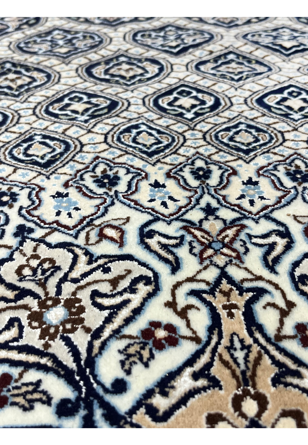 Close view of navy Gombadi motif with ivory floral medallion and silk outlined details on Persian Nain rug.