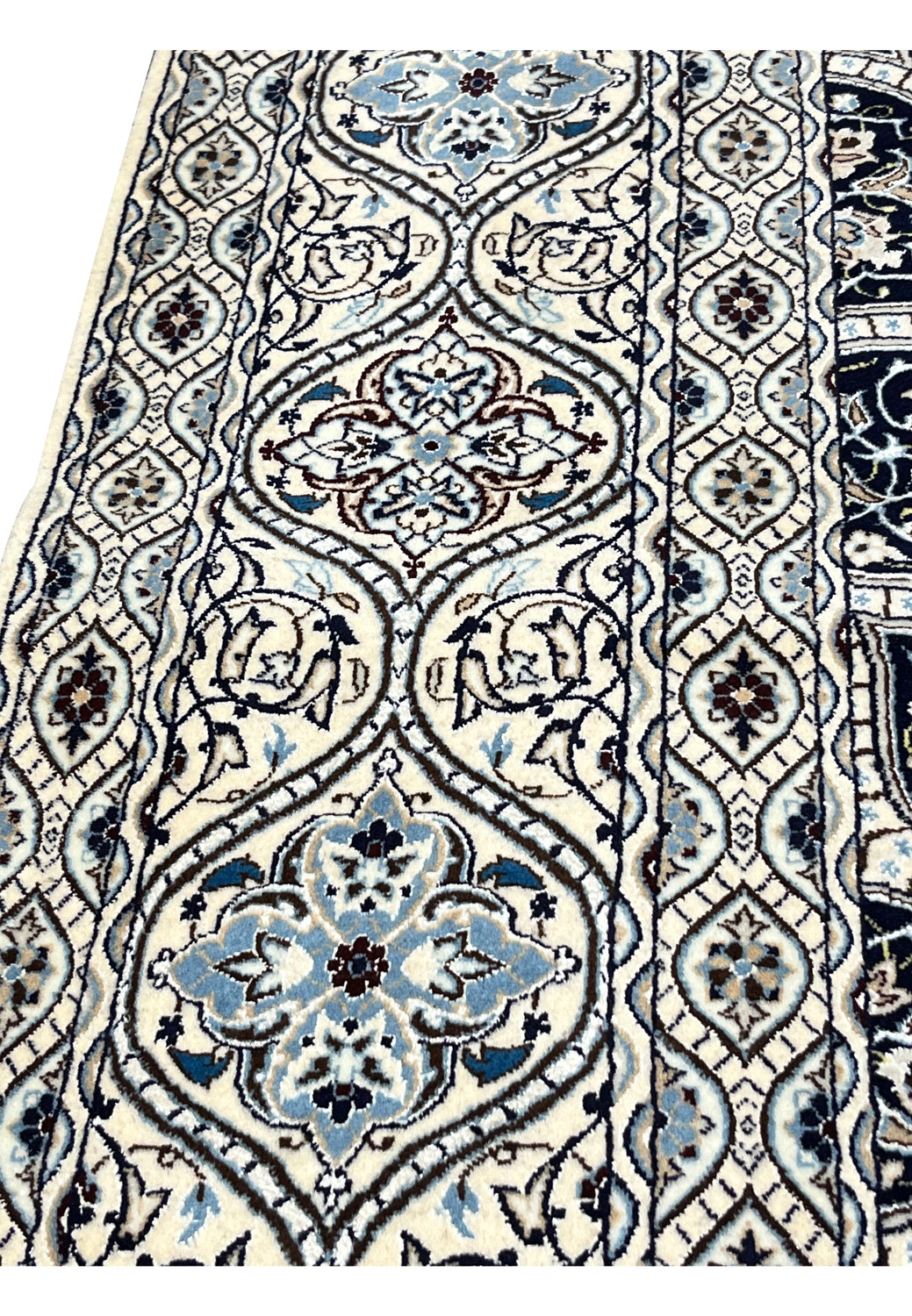 Closeup of Persian Nain Habibian border showing intricate vine scrolls light blue flowers and ivory guard bands.